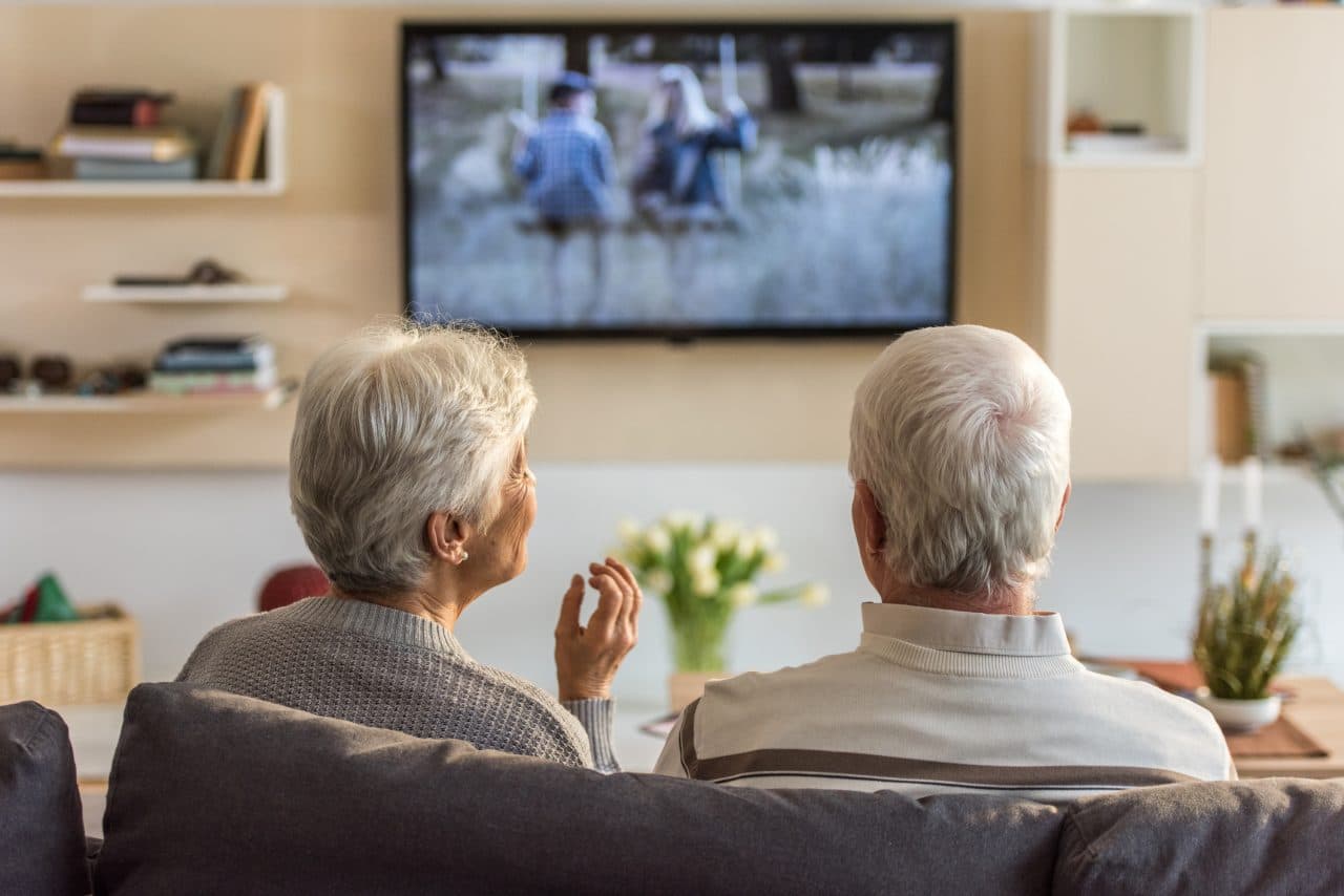 Older couple watching TV together.