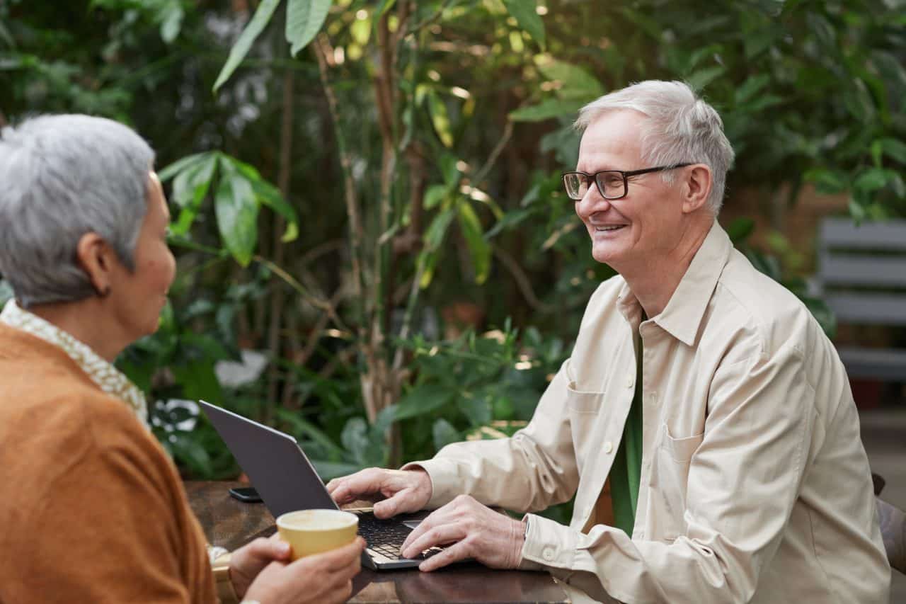 Older couple enjoying lunch at an outdoor cafe.