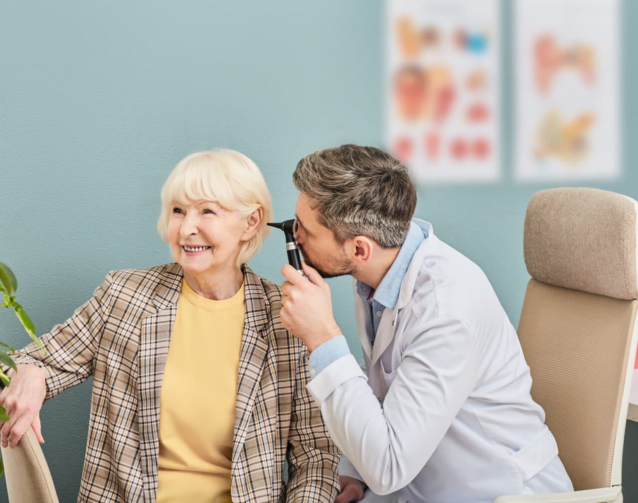 Senior woman taking control of her hearing health and receiving an ear exam.