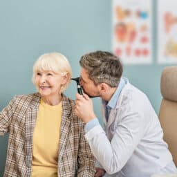 Senior woman taking control of her hearing health and receiving an ear exam.