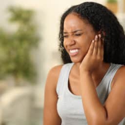 Woman with tinnitus holds ear